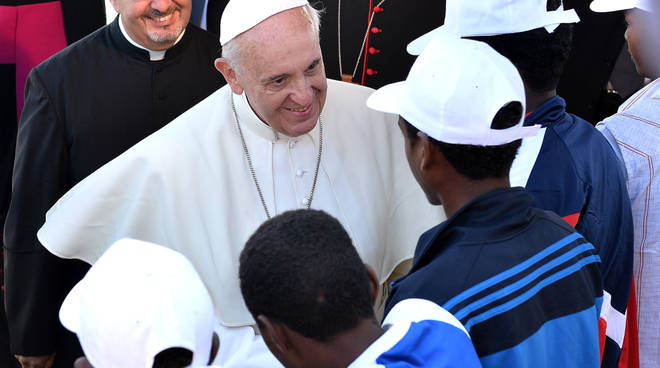 Papa Francesco con alcuni migranti 